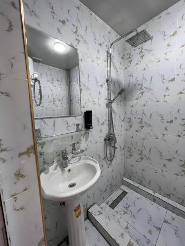 a white bathroom with a sink and a mirror at Guest House Medic in Nukus