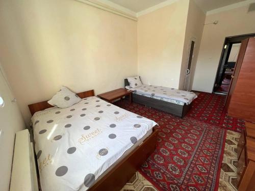 Zimmer mit 2 Betten und Teppichboden in der Unterkunft Guest House Medic in Nukus