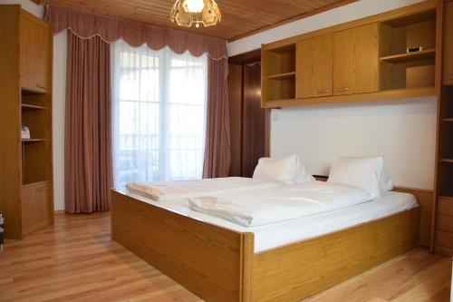 ein großes Bett in einem Zimmer mit Fenster in der Unterkunft Appartmenthaus Rosenhof in Podersdorf am See