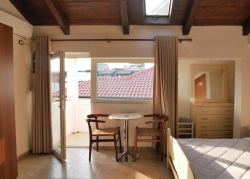 a bedroom with a bed and a table and a window at Kultura Hostel in Shkodër