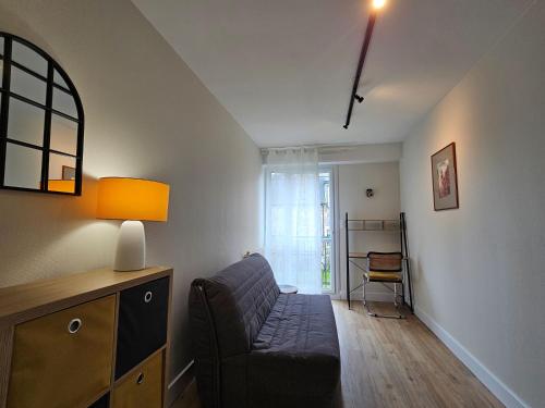 Le cosy duplex centre في دينان: غرفة معيشة مع أريكة ومصباح
