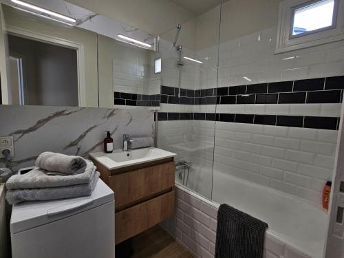 a bathroom with a sink and a bath tub at Le cosy duplex centre in Dinan
