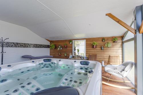 uma banheira num quarto com paredes de madeira em Villa - Spa Terre et Mer em Landévant