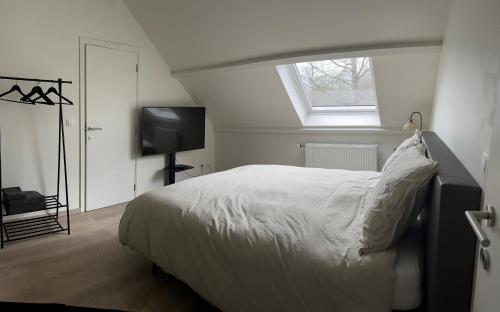 a bedroom with a white bed and a window at Ecole Buissonnière in Vielsalm