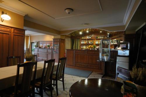 a restaurant with a bar with a table and chairs at Hotel Alexandra in Olesno