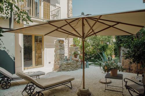 un patio con un grande ombrellone e due sedie di Residenza Vedovelli a Torri del Benaco