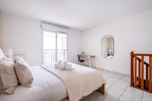 1 dormitorio blanco con 1 cama grande con almohadas blancas en Luxueux Appartement à La Défense, en Courbevoie