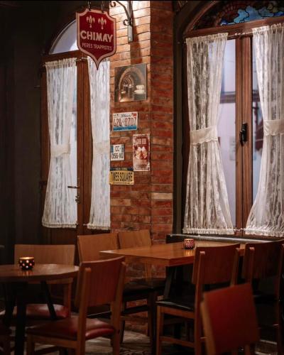 a dining room with tables and chairs and a window at Kultura Hostel in Shkodër