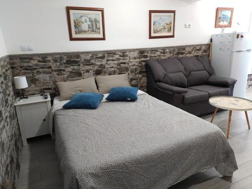 een slaapkamer met een bed, een bank en een stoel bij Relax Park 1 in Las Palmas de Gran Canaria