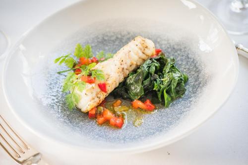 a plate of food with fish and vegetables on a table at Ballymaloe House Hotel in Ballycotton