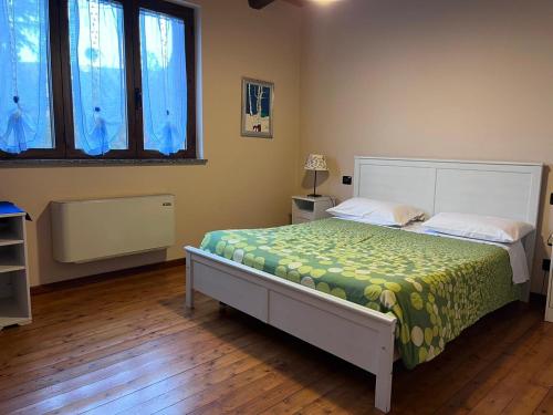 Agriturismo Vecchio Torchio في كانيلي: غرفة نوم بسرير وبطانية خضراء وصفراء