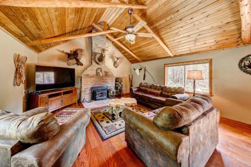 een woonkamer met leren banken en een open haard bij Longs Peak Cabin - Monthly Long-Term Vacation Rental 30 Days -- Estes Park cabin in Allenspark