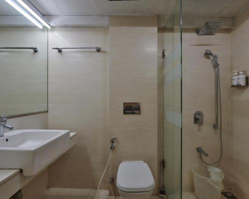 a bathroom with a sink and a toilet and a shower at Bentley Hotel Marine Drive in Mumbai