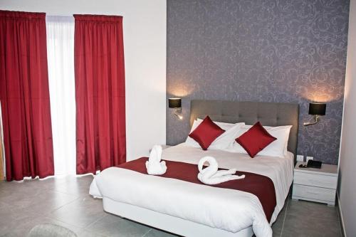 a bedroom with a large bed with swans on it at Fisherman's Cove Guesthouse in Marsaxlokk