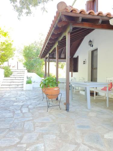 a patio with a table and a potted plant at Villa Panorama Garden Chorto in Chorto