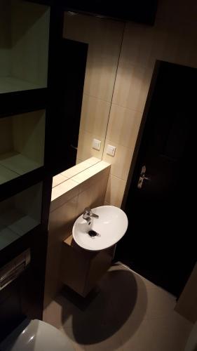 a bathroom with a white sink and a mirror at Apartament Big Studio mieszkanie KRAKÓW Śródmieście in Krakow