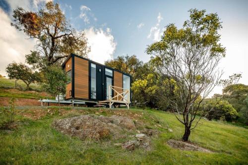 a tiny house on a hill with a bench at Montara Views 2 in Ararat