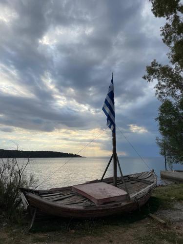 a boat with a flag on the side of the water at Villa Panorama Garden Chorto in Chorto