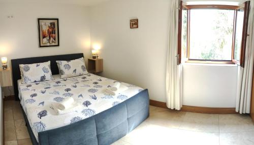 a bedroom with a blue and white bed with a window at Apartman Linda in Milna