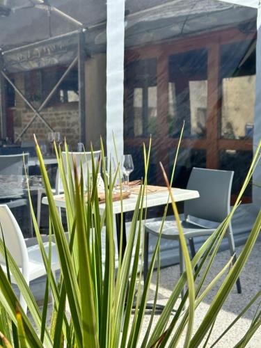 a table and chairs on a patio at Hôtel Restaurant le clos de l 'Ancien Pressoir in Commes