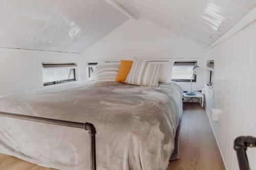 ein Schlafzimmer mit einem großen Bett in einem weißen Zimmer in der Unterkunft Noosa Tiny Home in Ringtail Creek