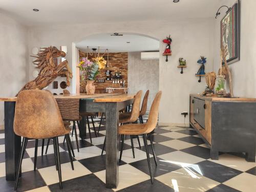 une salle à manger avec une table et des chaises dans l'établissement L'endroit incontournable, à Les Baïsses