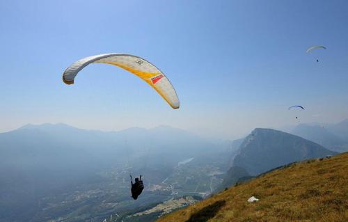 a person flying a parachute on a hill at Appartamento Masi in Lasino