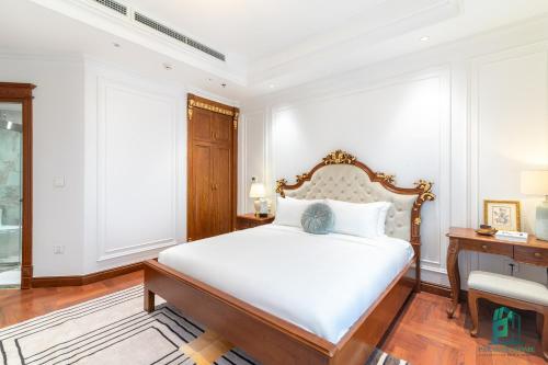 a bedroom with a large white bed and a desk at Luxe Paradise Suite Hotel Trich Sai in Hanoi
