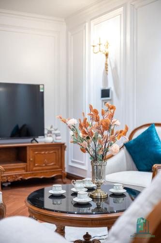 a living room with a vase of flowers on a coffee table at Luxe Paradise Suite Hotel Trich Sai in Hanoi
