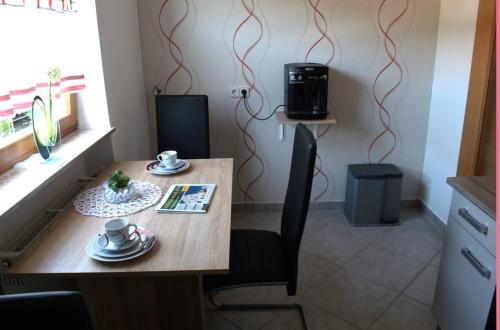 einen Holztisch mit 2 Stühlen und eine Kaffeemaschine in der Unterkunft Ferienwohnung Hüttinger/Summer in Pappenheim