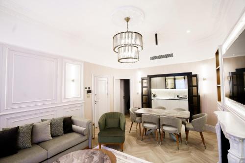 een woonkamer met een bank en een tafel en stoelen bij Holland Park Residence in Londen