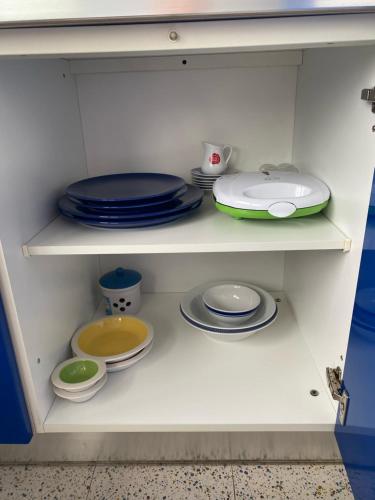 a white cabinet filled with plates and bowls and dishes at The Attic Apartment in Rome