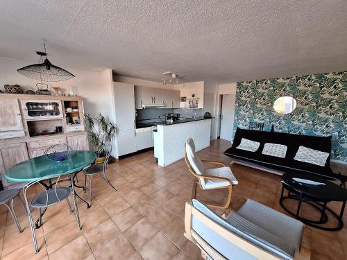 un salon avec une table et une cuisine dans l'établissement ROCADE DE COLLIOURE appt T4 avec grande terrasse et garage, à Collioure