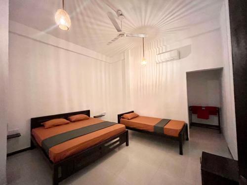 a bedroom with two beds and a ceiling at Sea La Vie in Arugam Bay