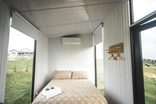 uma cama num quarto com uma grande janela em Bella Views em Heathcote