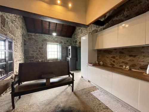 une cuisine avec un banc au milieu d'une pièce dans l'établissement Casa do Capitão de Cutelo - Gerês, à Terras de Bouro