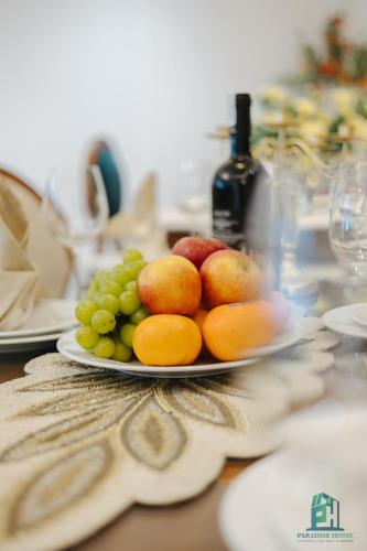 a plate of fruit sitting on a table at Luxe Paradise Suite Hotel Trich Sai in Hanoi