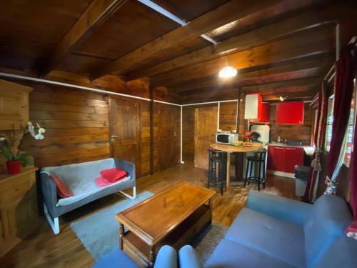 a living room with a blue couch and a table at Mon Chalet dans les bois in Villard-Saint-Sauveur