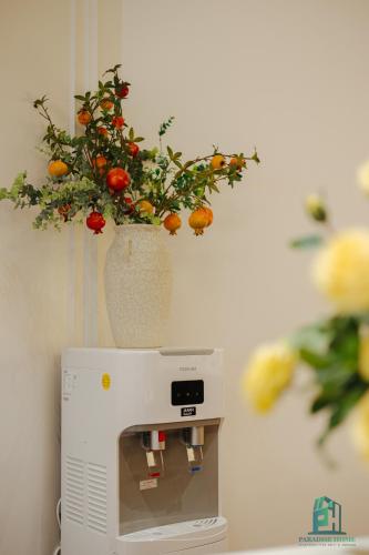 a vase with flowers on top of a microwave at Luxe Paradise Suite Hotel Trich Sai in Hanoi