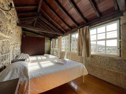 een slaapkamer met een groot bed in een gebouw bij Casa do Capitão de Cutelo - Gerês in Terras de Bouro