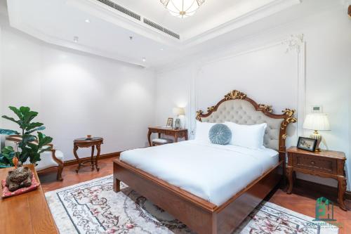 a bedroom with a king sized bed and a table at Luxe Paradise Suite Hotel Trich Sai in Hanoi