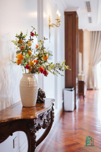 a vase of flowers sitting on a table at Luxe Paradise Suite Hotel Trich Sai in Hanoi