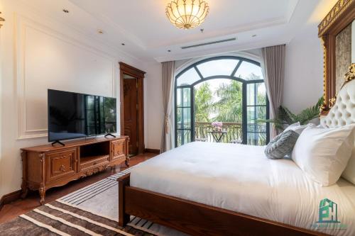 a bedroom with a large bed and a flat screen tv at Luxe Paradise Suite Hotel Trich Sai in Hanoi