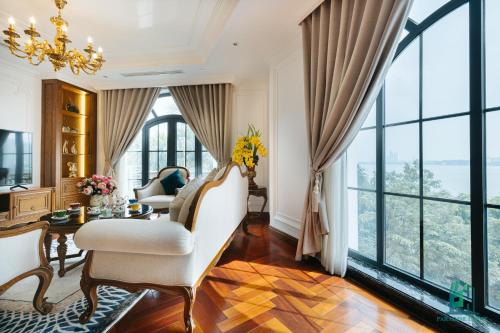 a living room with a chandelier and large windows at Luxe Paradise Suite Hotel Trich Sai in Hanoi