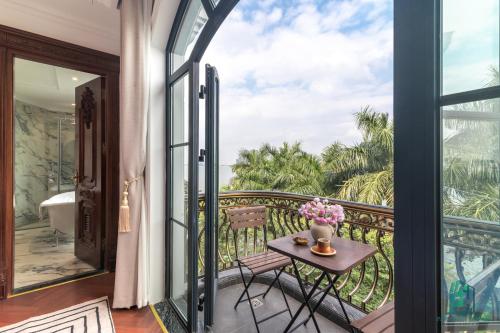 a balcony with a table with flowers on it at Luxe Paradise Suite Hotel Trich Sai in Hanoi
