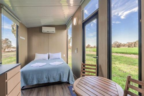 a small bedroom with a bed and a large window at Avon River Homestead 