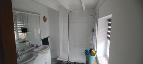 a white bathroom with a sink and a shower at MAISON DE VACANCES aU 91 in Ardres