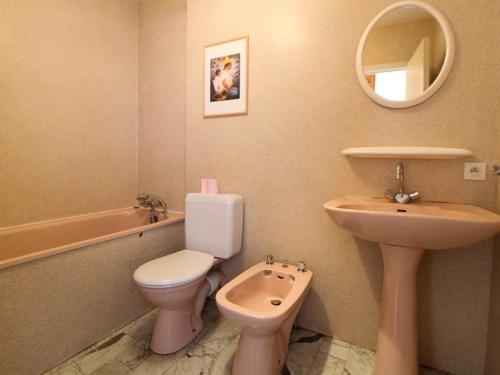 W łazience znajduje się różowa toaleta i umywalka. w obiekcie Studio Royan, 1 pièce, 3 personnes - FR-1-494-47 w mieście Royan