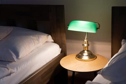 a lamp sitting on a table next to a bed at Hotel U Beránků in Libochovice