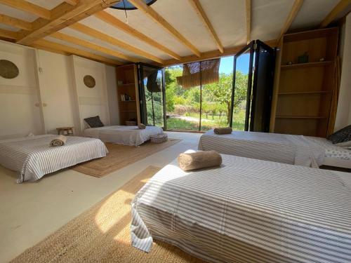 a bedroom with two beds and a large window at The4Elements in Monda